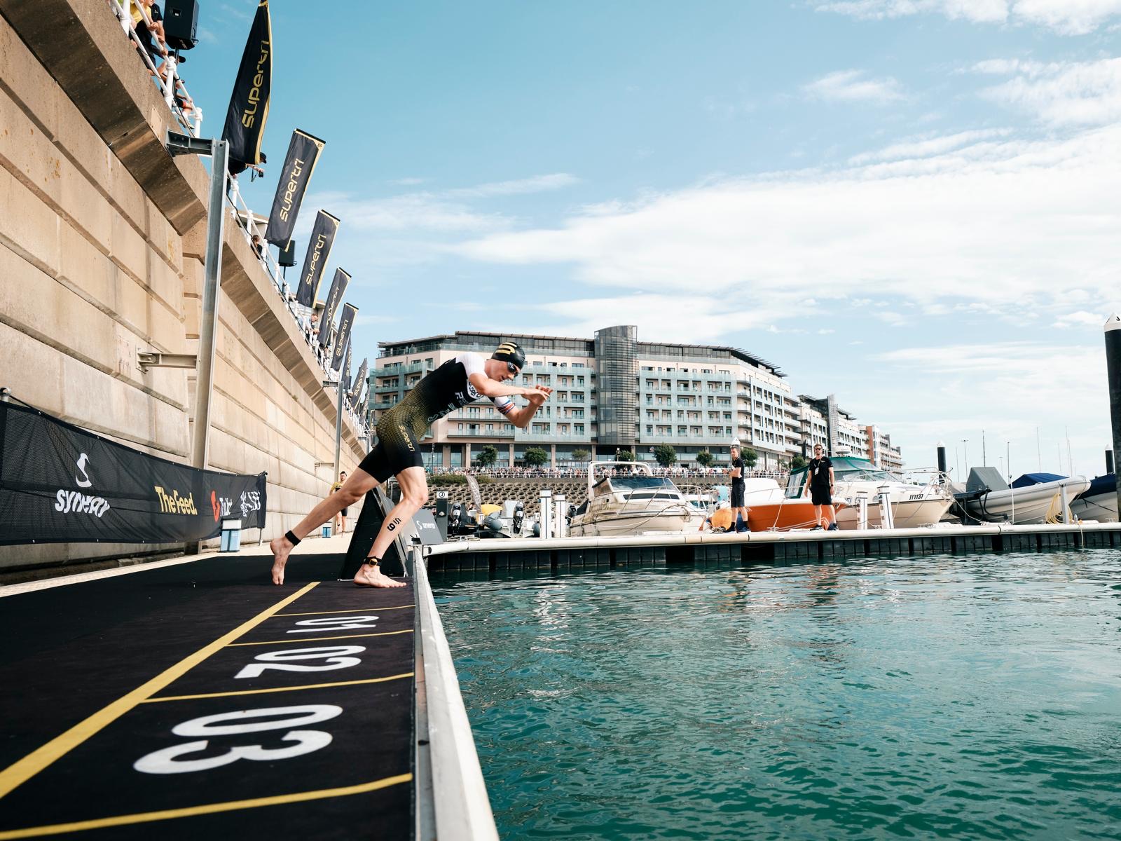 Michael Gar diving off the pontoon at the start of the supertri race in Jersey